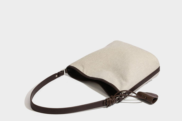 Oatfarbene Canvas-Schultertasche mit dunkelbraunem Besatz in Lederoptik, langem verstellbarem Riemen und angebrachter Mini-Tasche mit Überschlag, Detailansicht