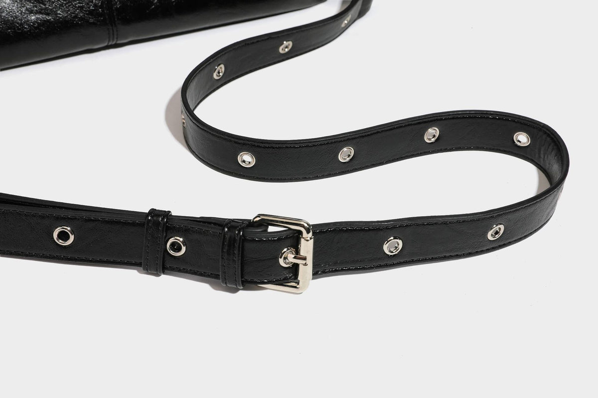 Black glossy leather-look slouchy shoulder bag with silver stud and eyelet hardware, top zip closure, front zip pocket, and