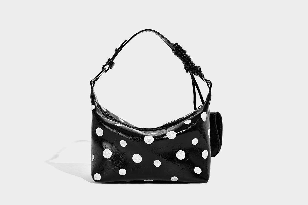 Kompakte glänzende Hobo-Schultertasche in Schwarz mit weißen Punkten, Reißverschluss, Beschlägen in Gunmetal und befestigtem Überschlag vorne