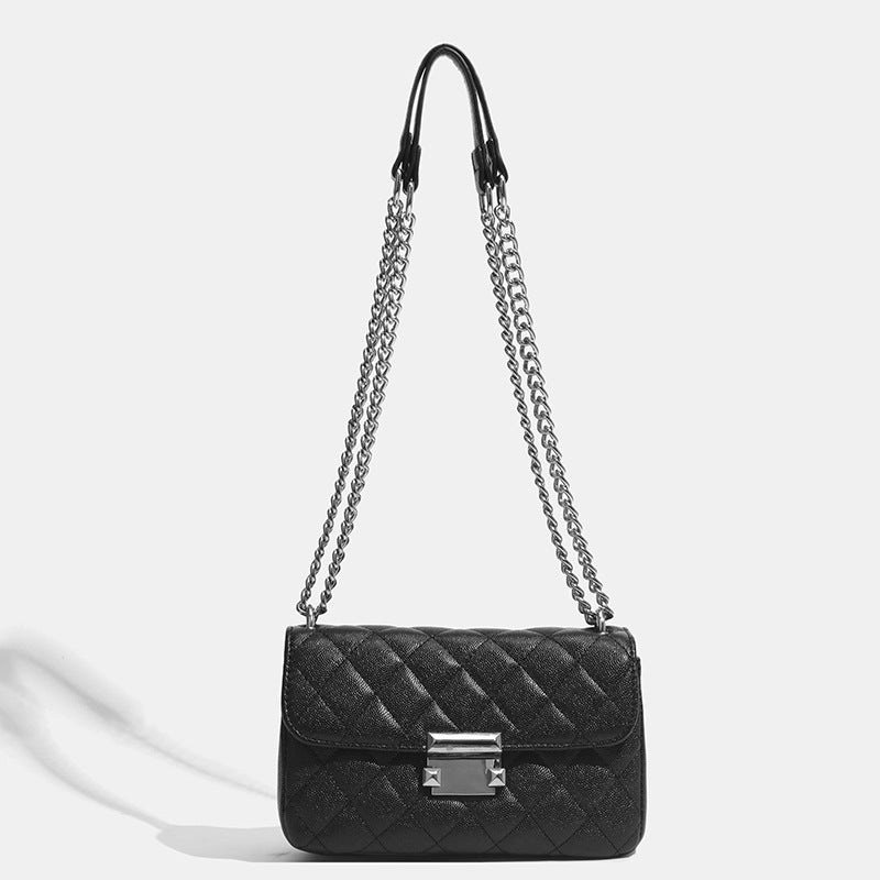 Kleine strukturierte Schultertasche mit Rautensteppung, doppeltem silberfarbenem Kettenriemen und rechteckigem silberfarbenem Verschluss, Detailansicht