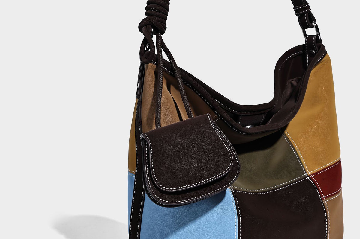 Weich fallende Patchwork-Bucket-Schultertasche mit Einsätzen in Dunkelbraun, Cognac, Senfgelb, Olivgrün, Rot und Hellblau sowie Kontrastnähten