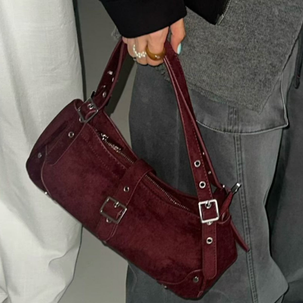 Geschwungene Hobo-Schultertasche mit matter Wildlederoptik, Riemen mit Schnalle in Silberoptik, Ösen, Nieten und Reißverschluss, Detailansicht