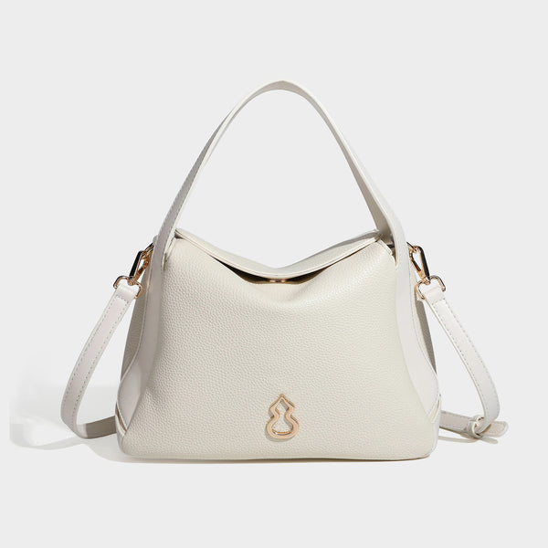 Structured pebbled leather-look shoulder bag with flap top, gold-tone emblem hardware, dual top handles, and detachable