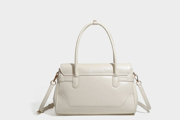 Structured glossy leather-look satchel bag with flap closure, gold-tone buckle accents, double top handles, detachable