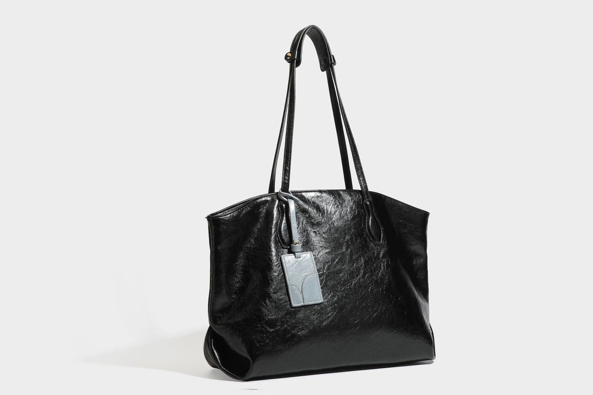 Übergroße, lässig fallende Tote-Bag aus glänzendem, geknittertem Lederimitat in dunklem Burgunderrot mit zwei langen Schulterriemen und kontrastierendem