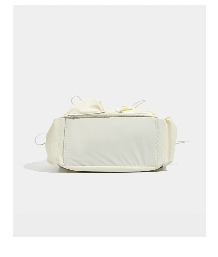 Puffy matte nylon mini backpack with drawcord gathered front pockets and silver-tone hardware, detail view 11