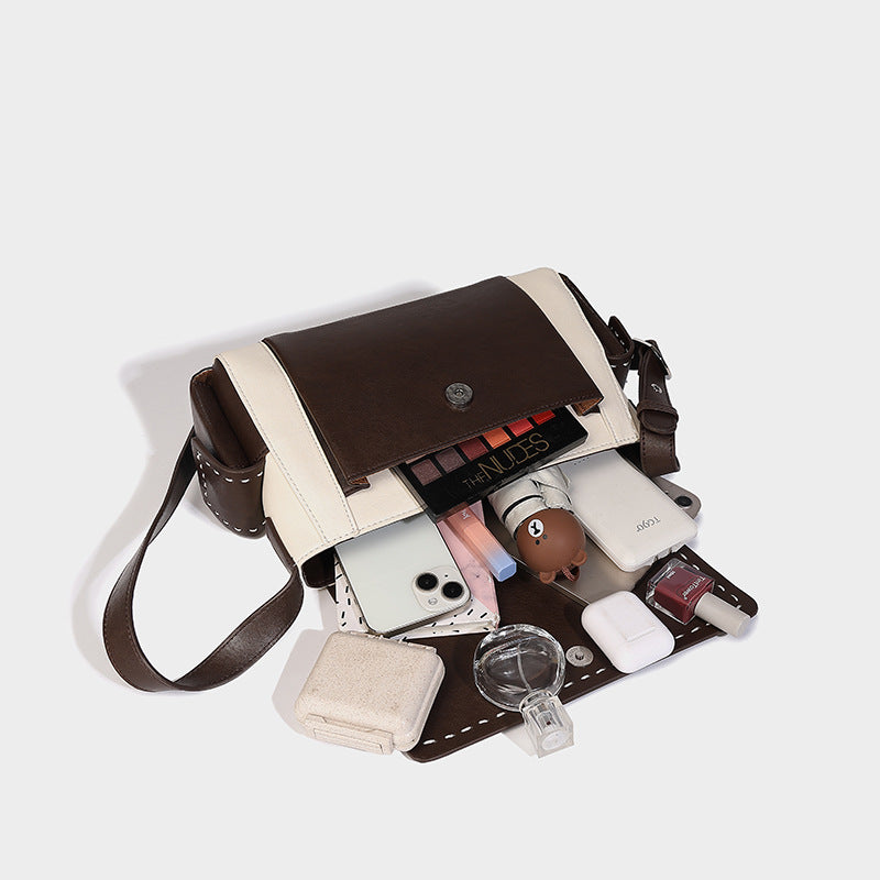 Structured flap crossbody bag in dark brown and cream color-block with white contrast stitching, adjustable shoulder strap