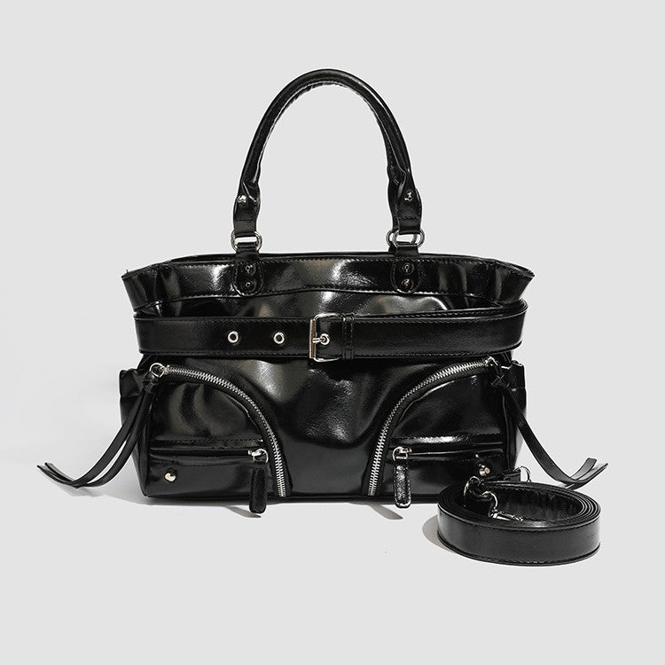 Black glossy structured tote bag with rivet and buckle detail, dual top handles, and detachable shoulder strap, front view