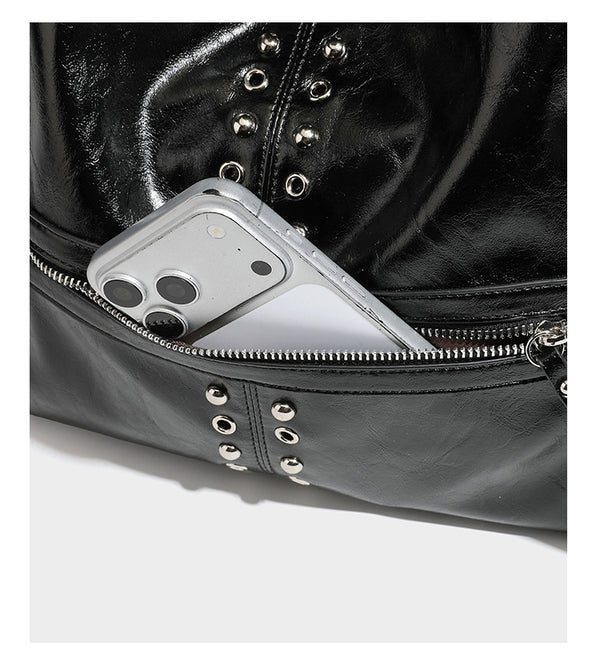 Black glossy leather-look slouchy shoulder bag with silver stud and eyelet hardware, top zip closure, front zip pocket, and