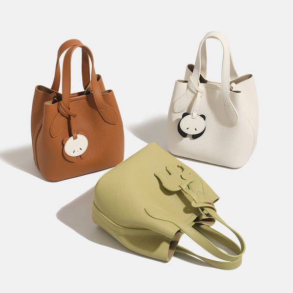 Pebbled leather-look bucket tote with elephant charm pendant, dual top handles, and detachable shoulder strap, detail view 2