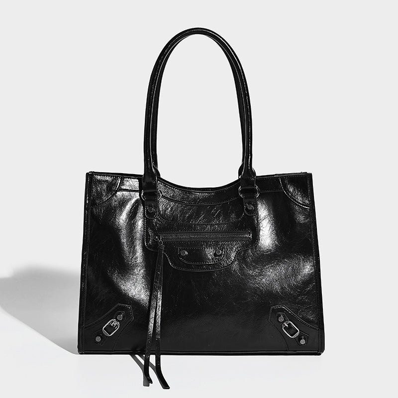 Large structured leather-look tote bag with front zip pocket, moto hardware accents, and long double shoulder straps, detail