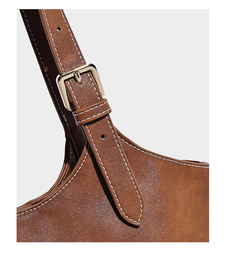 Große, strukturierte Schultertasche im Tote-Stil in Braun und Lederoptik mit langen Doppelriemen, Schnallenbeschlägen, Quasten-Anhänger und geschwungener