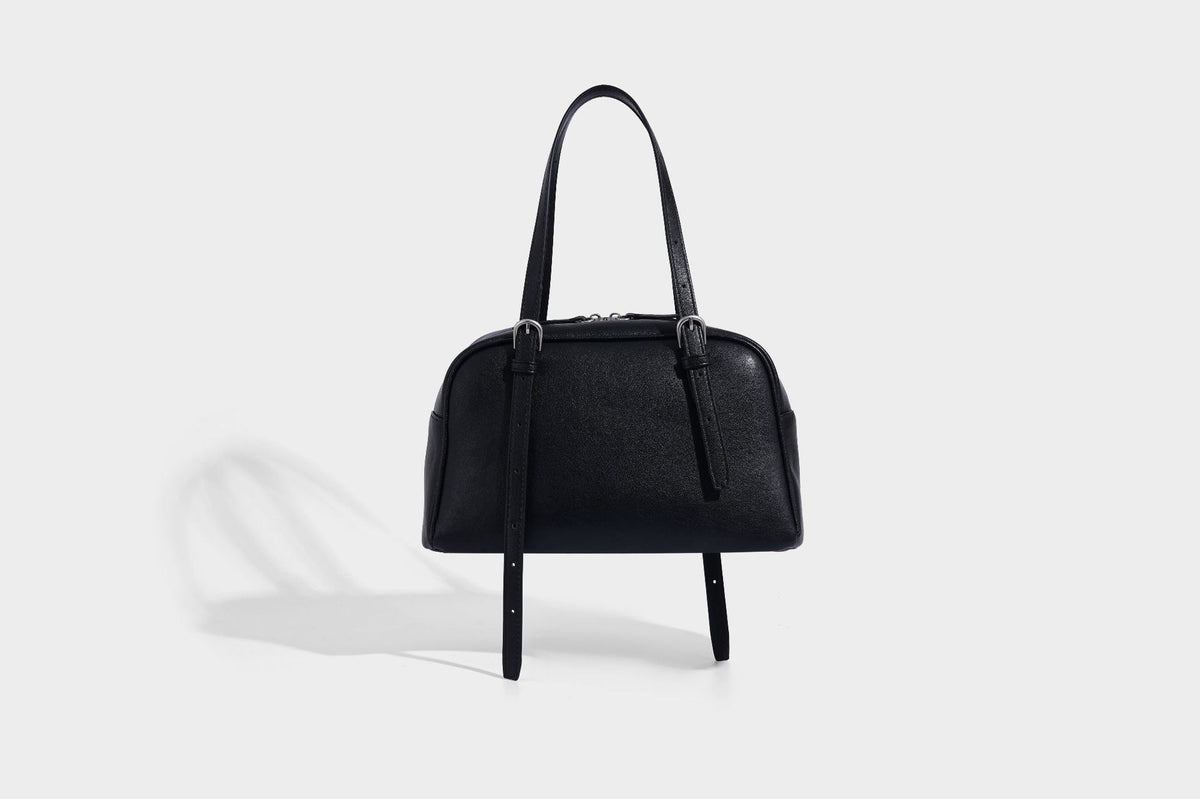 Structured dome-shaped shoulder bag with leather-look finish, top zipper closure, dual adjustable slim straps, and, detail