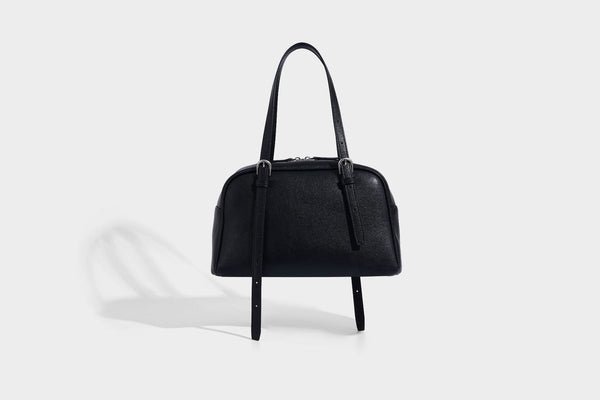 Structured dome-shaped shoulder bag with leather-look finish, top zipper closure, dual adjustable slim straps, and, detail