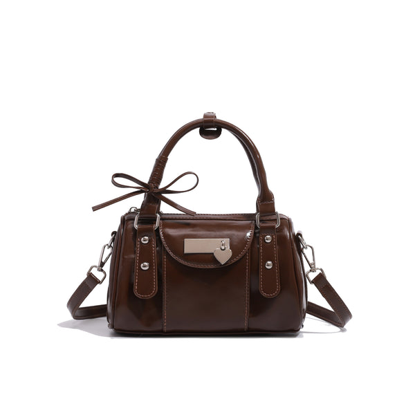 Kleine strukturierte Henkeltasche mit glänzender Oberfläche, zwei Tragegriffen, aufgesetzter Fronttasche, herzförmigem Verschlussanhänger und silberfarbenem