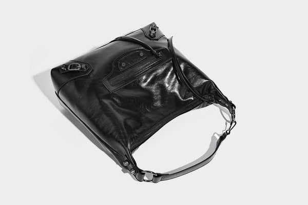 Große, glänzende Hobo-Schultertasche mit geknautschtem Effekt, dunkelfarbenen Nieten, Reißverschluss, vorderem Reißverschlussfach und verstellbarem Crossbody-Riemen