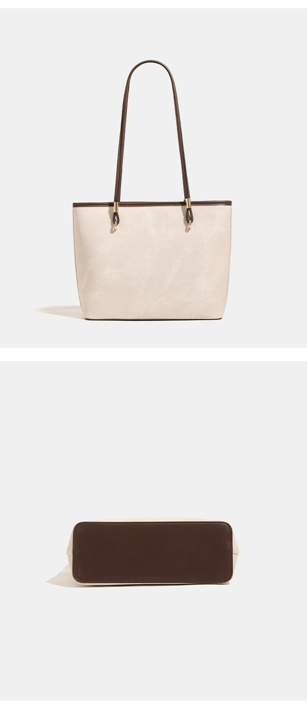 Große, strukturierte Tote-Bag mit offenem Oberteil in Creme, dunkelbrauner Borte in Lederoptik, zwei Schulterriemen und dreieckigem Logo-Badge
