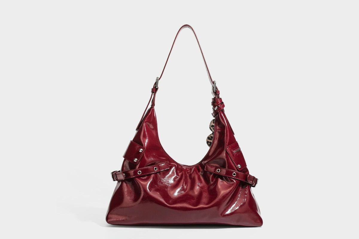 Glänzende dunkelbraune, lässig geschnittene Hobo-Schultertasche mit Riemendetail mit silberfarbenen Ösen, Reißverschlussfach auf der Vorderseite und Herz mit Leopardenmuster