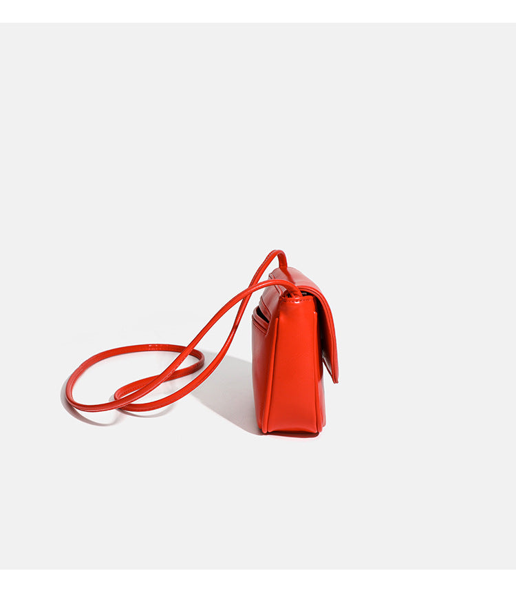 Compact rounded rectangular flap crossbody bag with glossy leather-look finish and long shoulder strap, detail view 12