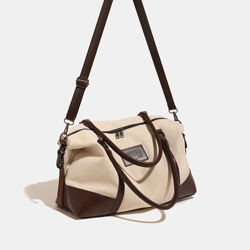 Large cream canvas tote bag with dark leather-look trim, dual top handles, and detachable shoulder strap, detail view 4