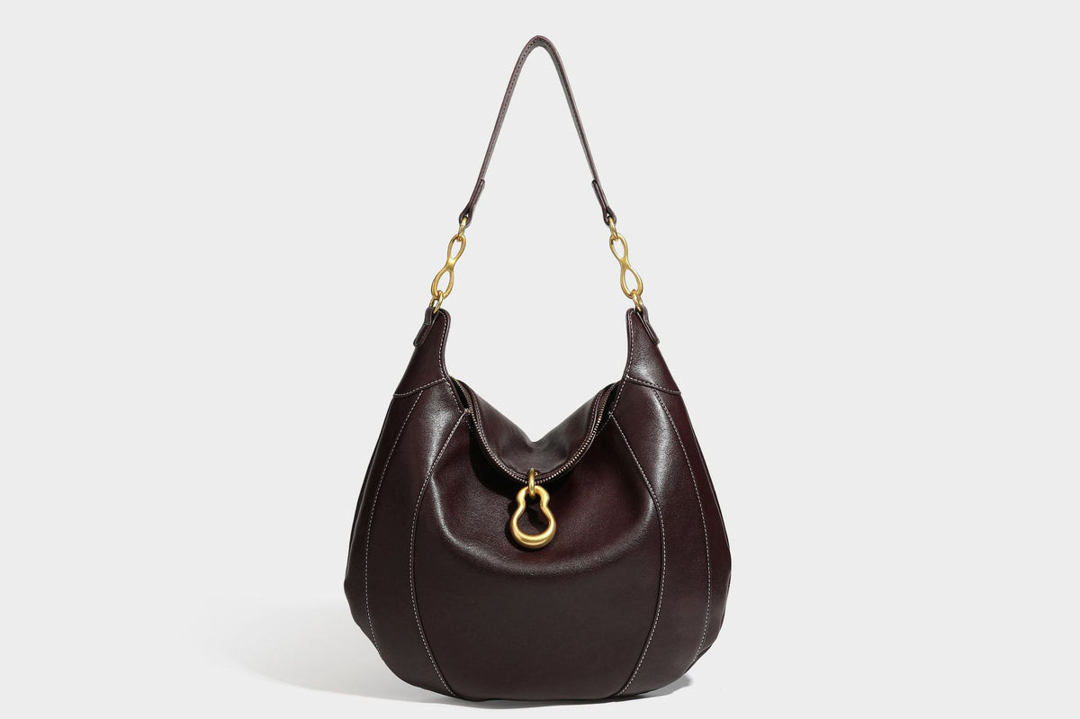 Lässige halbmondförmige Hobo-Schultertasche in Dunkelbraun mit goldfarbenem Ring und Kettenglied-Beschlägen sowie Reißverschluss oben, Detailansicht