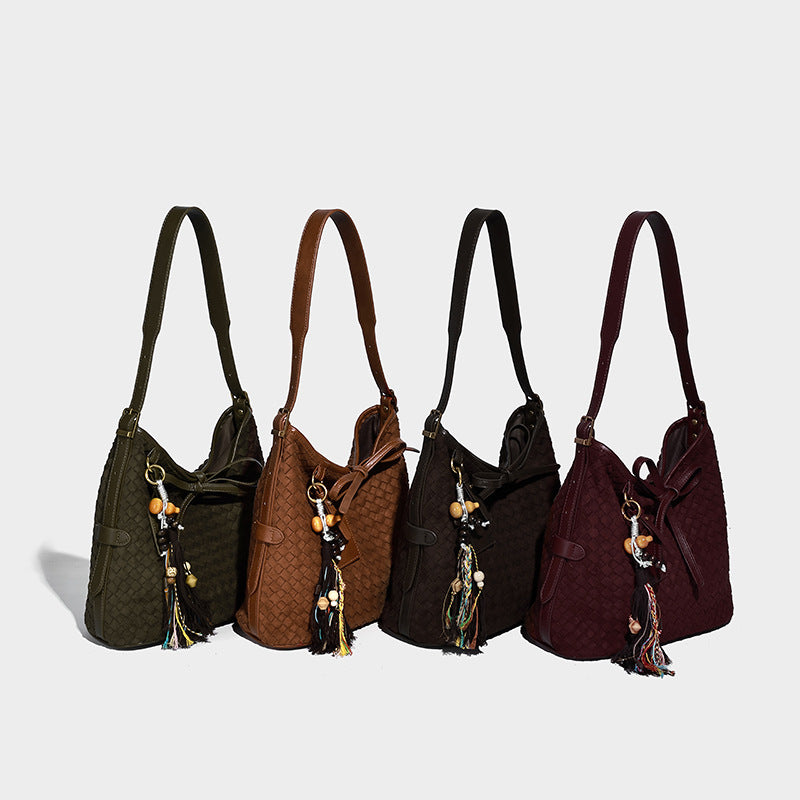 Dark brown woven-texture bucket bag with tie-knot closure, gold-tone hardware, and adjustable shoulder strap, detail view 2