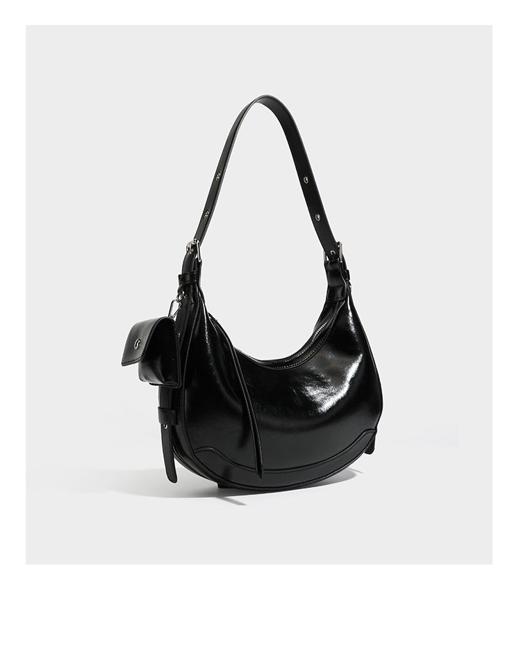 Glossy leather-look crescent hobo shoulder bag with dark contrast trim, silver-tone hardware, and attached mini flap pouch