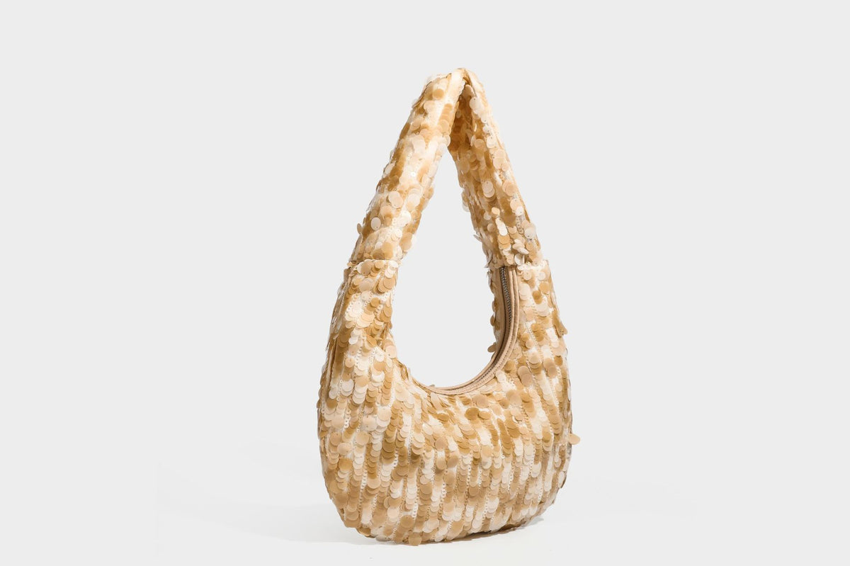 Slouchy crescent hobo shoulder bag covered in overlapping reflective sequin discs with a single integrated strap and top-zip