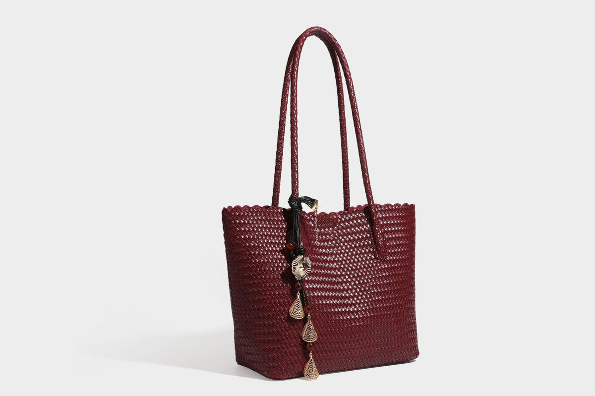 Large open-top woven leather-look tote bag in dark brown with scalloped edge, braided double shoulder straps, and decorative