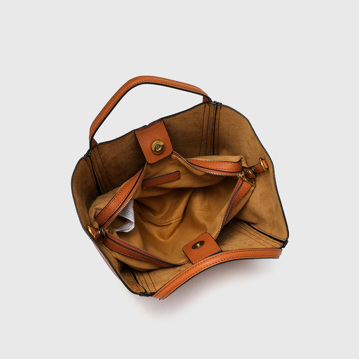 Structured open-top tote bag in tan brown pebbled leather-look finish with vertical seam accents, black edge piping, curved