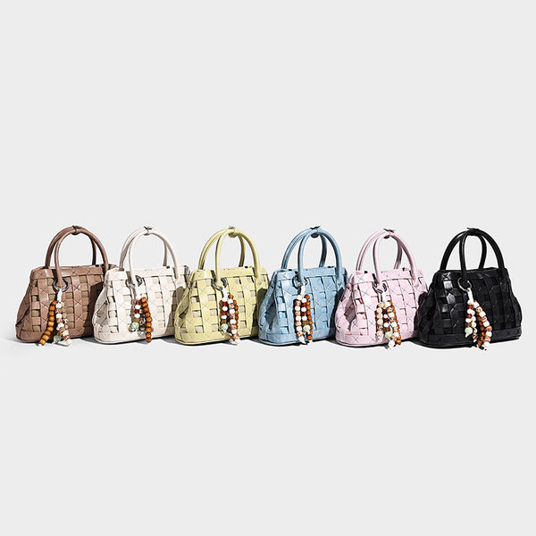 Small structured woven satchel tote with rounded top handles, silver-tone ring hardware, and bead tassel charm, detail view 2