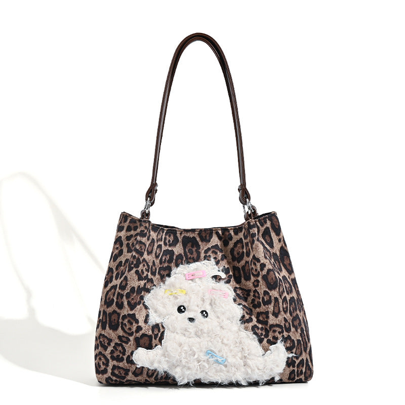 Leopard-print fabric tote bag with white plush teddy bear appliqué and brown leather-look shoulder straps, detail view 5