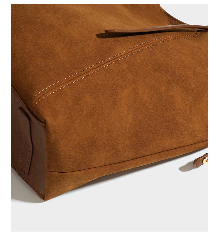 Oversized suede-finish tote shoulder bag in caramel brown with slim leather-look straps and gold-tone logo hardware, detail