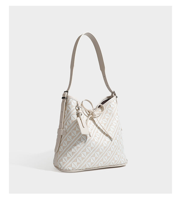 Woven geometric bucket shoulder bag in white and dark brown two-tone pattern with leather-look trim and drawstring top