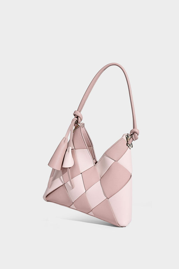 Compact bucket shoulder bag with black-and-white diamond patchwork panels, knotted top handle, gold-tone hardware, and