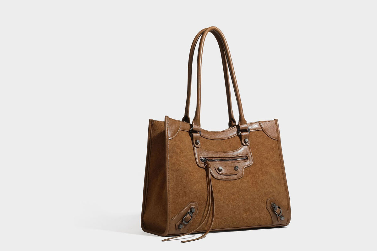 Large structured tote bag with matte suede-like body, smooth leather-look trim, front zip pocket, stud hardware, and
