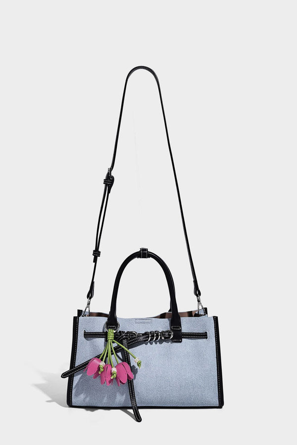 Structured rectangular tote satchel in denim-look fabric with dark trim, knotted front strap hardware, and detachable, detail