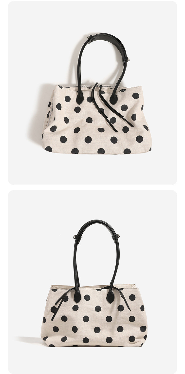 Cream canvas tote bag with black polka dots, rounded leather-look handles, and zip-top closure, detail view 10