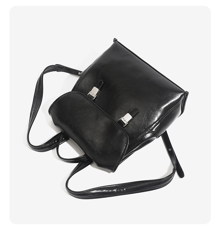 Structured glossy leather-look flap backpack handbag with dual buckle closures, top handle, and silver-tone hardware, detail