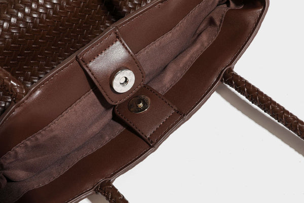 Structured woven leather-look tote bag in dark brown with long shoulder straps, side drawstring ties, and gold filigree