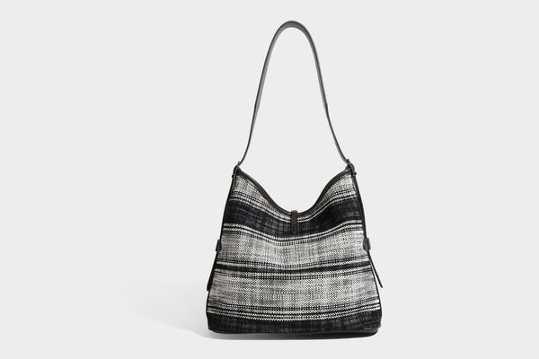 Schwarz-weiß karierte Hobo-Schultertasche aus gewebtem Material mit dunkelbrauner Einfassung in Lederoptik, Kordelzugverschluss und langem, verstellbarem