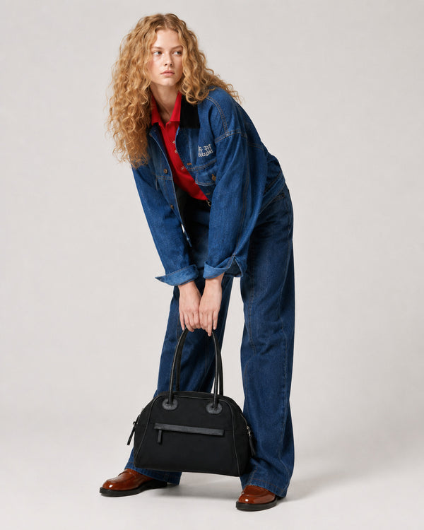 Structured dome top-handle bag in matte nylon with pebbled vegan leather-look trim, zip-top closure, front slip pocket, and