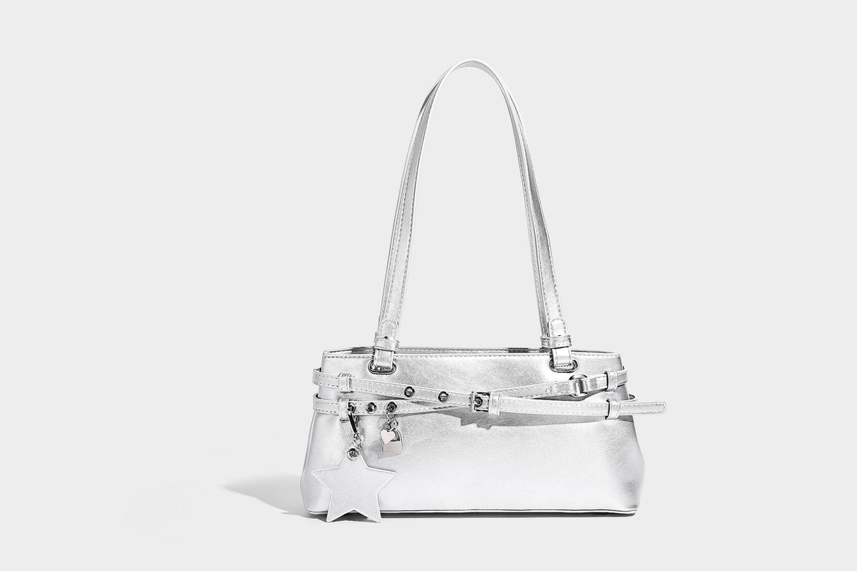 Structured glossy leather-look shoulder bag with wraparound belt straps, silver-tone hardware, and dangling star charm