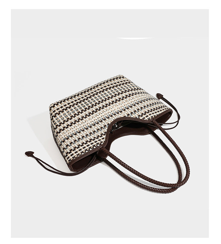 Large woven checker-pattern tote bag with dark braided shoulder straps, leather-look trim, and drawstring side ties, detail
