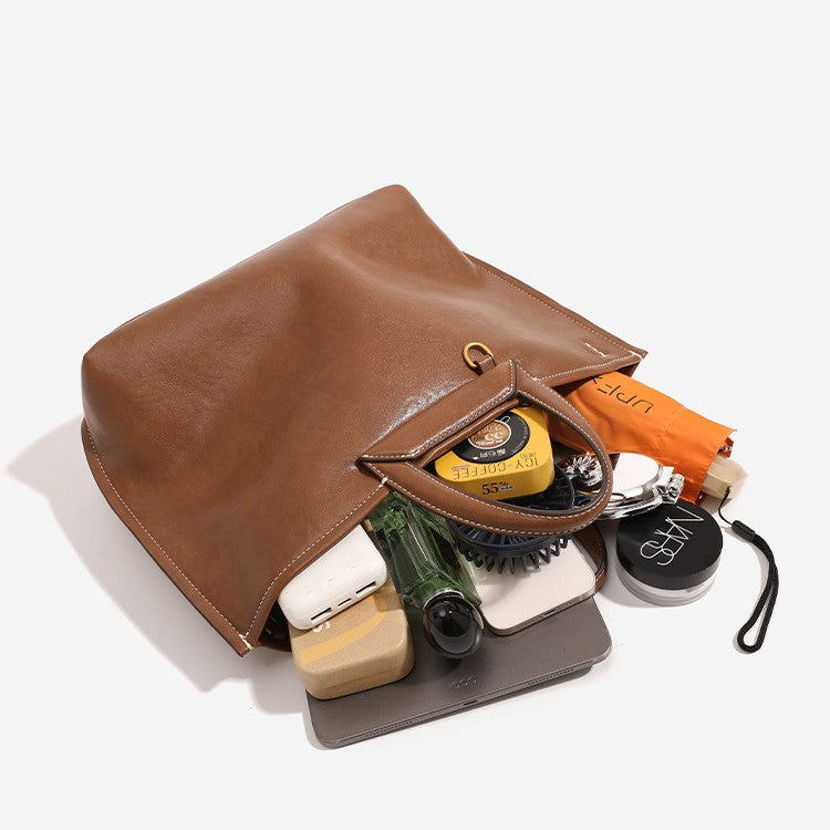 Structured cognac brown leather-look tote bag with fold-ear side panels, top handles, gold-tone hardware, and detachable