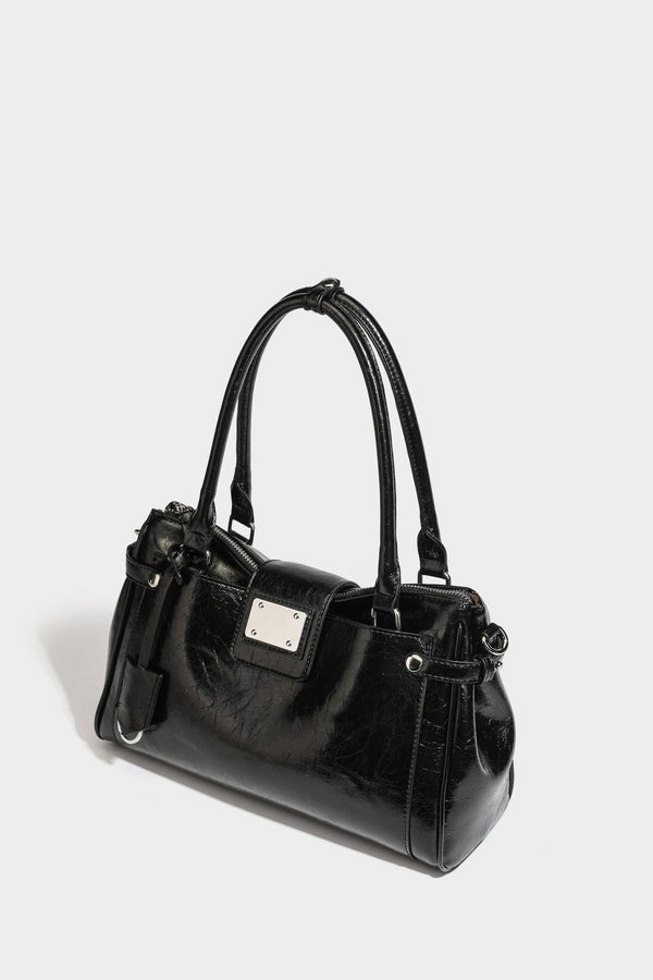 Structured glossy crinkled leather-look satchel with double top handles, front metal-plaque tab, silver-tone hardware, and