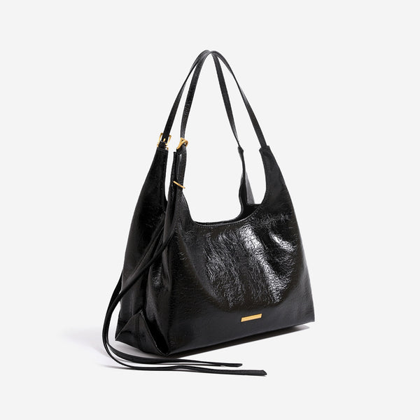 Slouchy hobo shoulder bag in crinkle high-gloss leather-look finish with gold-tone bar hardware and adjustable strap, detail