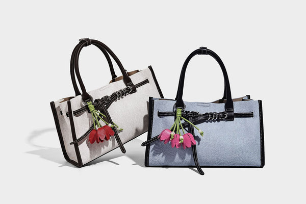 Structured rectangular tote satchel in denim-look fabric with dark trim, knotted front strap hardware, and detachable, detail