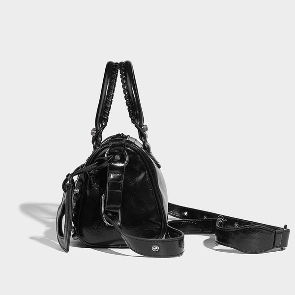 Glossy studded mini satchel bag with braided top handles, front zip pocket, heart charm, and detachable crossbody strap