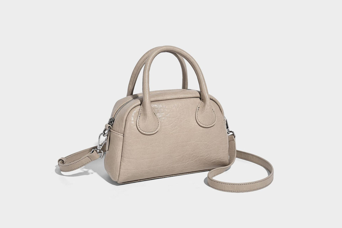 Mini-Henkeltasche in strukturierter Kuppelform in Pastellgelb mit genarbter Lederoptik, silberfarbenen Beschlägen und abnehmbarem